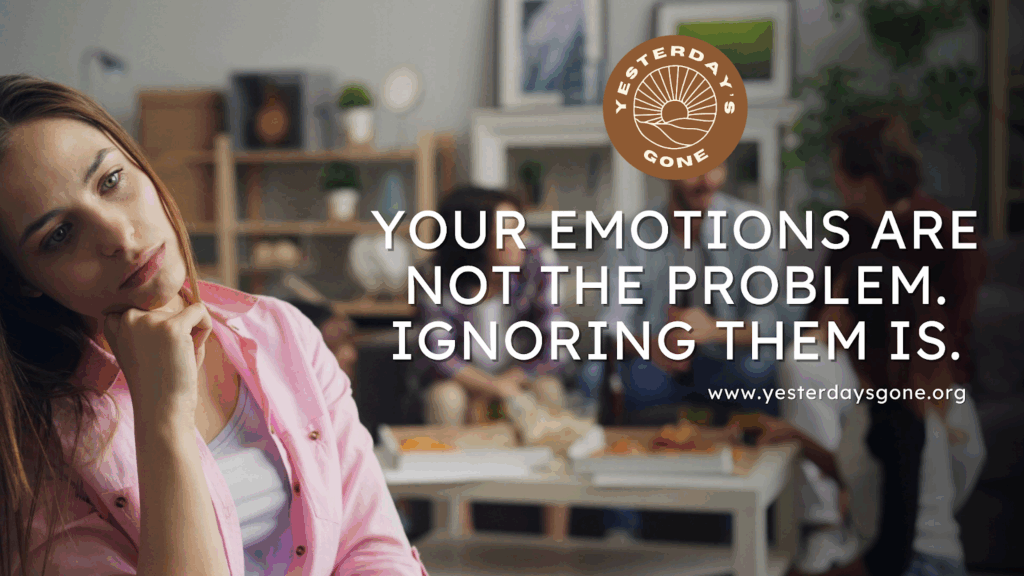 A thoughtful young woman sits with her chin resting on her hand, looking distant and reflective while a small group talks together in the blurred background. The Yesterday’s Gone logo appears in the top right, with the text: ‘Your emotions are not the problem. Ignoring them is.’ and the website www.yesterdaysgone.org.